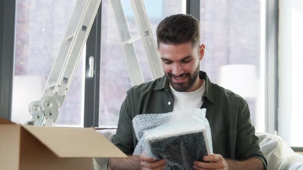 Man with Adhesive Tape Gun Packing Box at Home