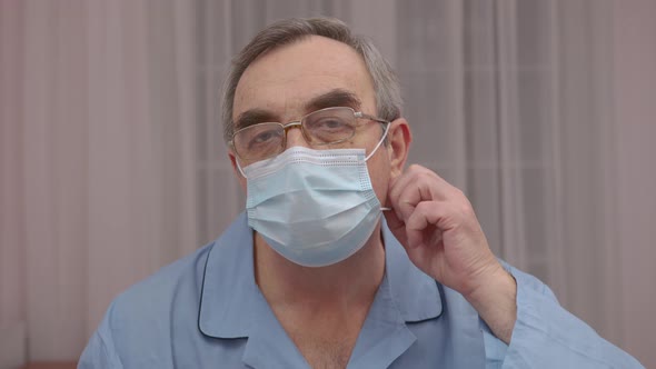 Close Up Portrait Elderly Man Takes Off a Medical Mask His Face