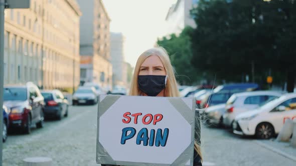 Woman in Protective Mask Protesting to Stop Pain By Holding Steamer