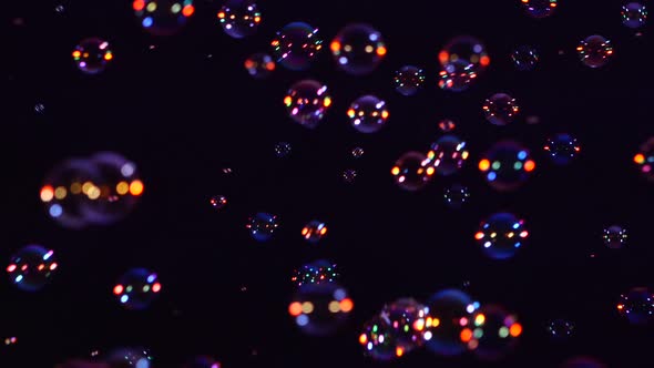 Blue, Red and Orange Soap Bubbles on Black, Background, Close Up