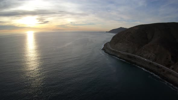 View Of The Pacific Coast Highway Curving Around Steep Santa Monica Mountains At Sunset