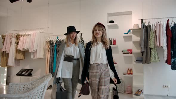 Happy Female Shoppers with Shopping Bags Leaving Fashion Store