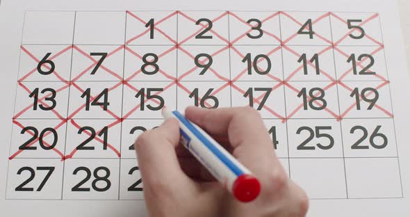 Man's Hand Write Down the 2122232425Th Day on the Calendar Using a Red Pen