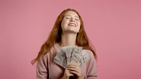 Amazed Happy Excited Woman Showing Money - U.S. Currency Banknotes on Pink Wall. Girl Scattering