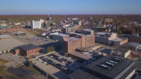 Wide aerial of trafficked streets in Muskegon, MI, backward motion