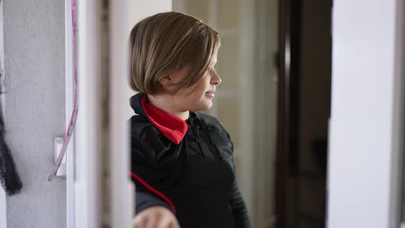 Caucasian Little Boy Standing at Open Door Waiting for Girl Appearing Scaring Looking at Camera