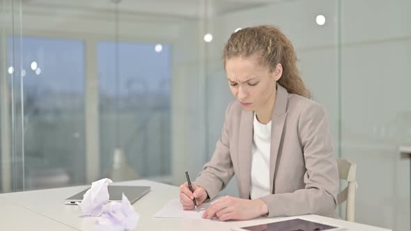 Young Businesswoman Trying To Write on Documents in Office