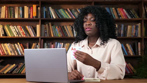 AfricanAmerican Teacher Shows Cards with Letters to Screen