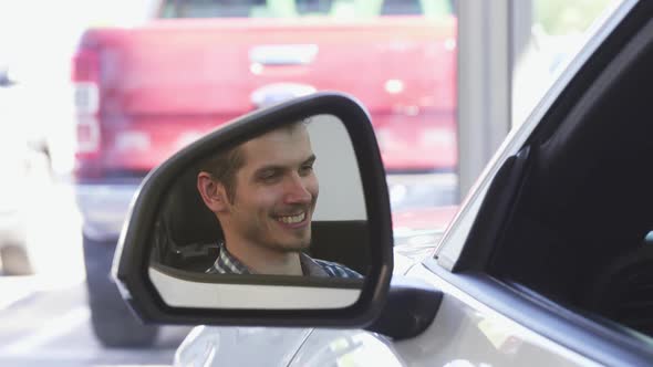 Happy Male Driver Smiling in the Side Mirror of a Car