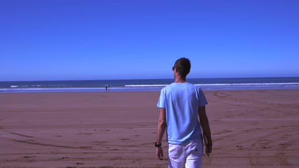 Young Man Working Using Laptop Computer on a Beach