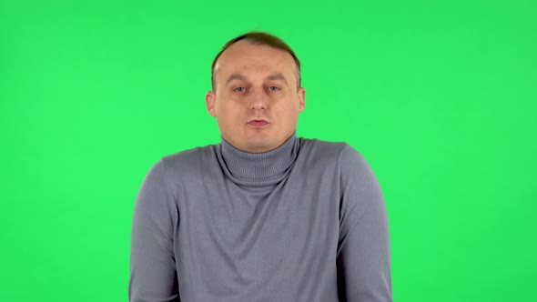 Portrait of Displeased Man Indignantly Talking To Someone, Looking at the Camera. Green Screen