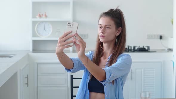 Portrait of Woman Taking Selfie Photo in Modern Kitchen