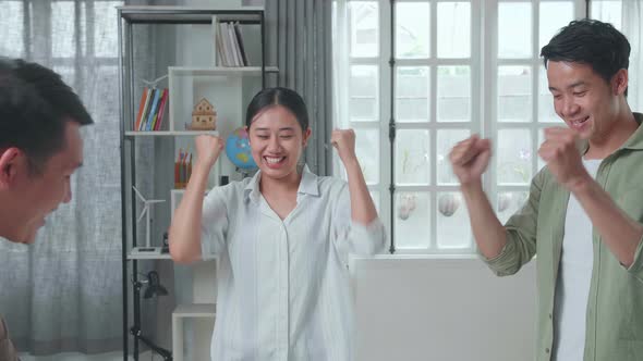 Group Of Asian Engineers Celebrating While Working At The Office