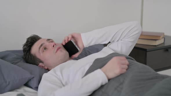 Man Talking on Smartphone While Sleeping in Bed