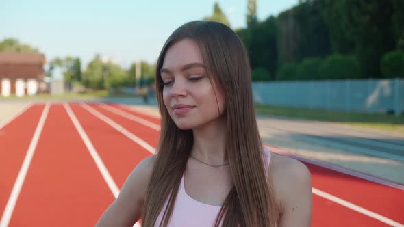 Beautiful Blonde Woman Athlete at the Stadium Breathing and Preparing to Start the Race