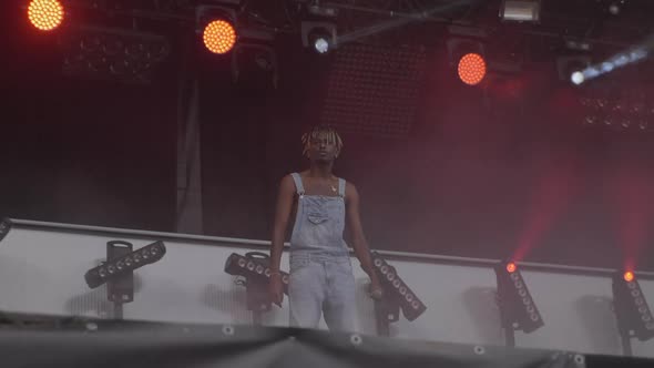 Black rapper in overalls on stage