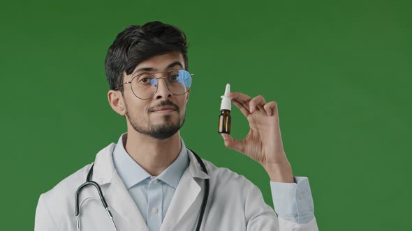 Arabian Young Male Hispanic Indian Doctor in White Coat Isolated in Green Studio Recommend at Camera
