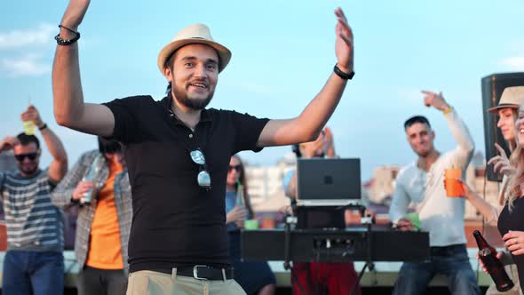 Happy Caucasian Man in Hat Dancing Active Raising Hands and Singing Enjoying Music at Rooftop Party