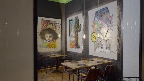 Pushin of Colorful Artwork on Walls Over Tables in Cozy Restaurant