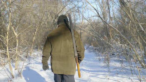 Hunter Walking in the Snowy Winter Forest. Winter Hobby, Sun, Hunting Concept.