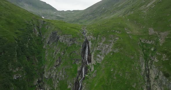 cinematic view of waterfall in green mountains valley