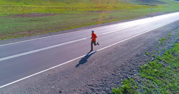 Low Altitude Flight in Front of Sporty Man at Perfect Asphalt Road