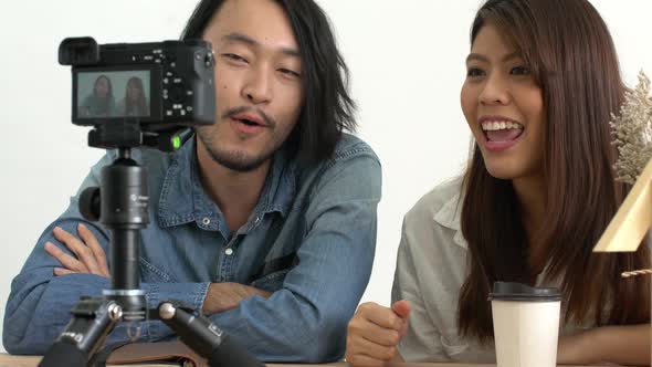 asian couple blogger or vlogger lives on social media with good story to camera home background