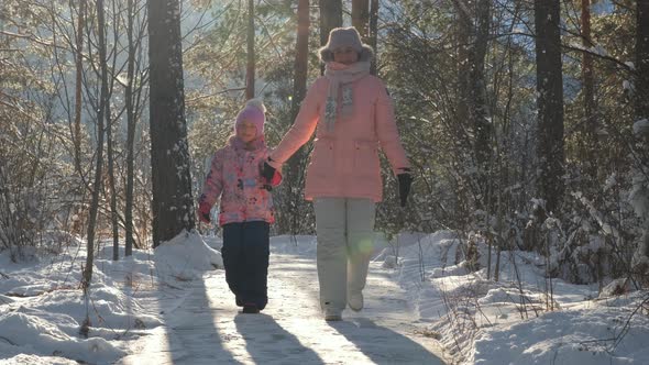 Woman and Child Walk in Sunny Frosty Winter Day