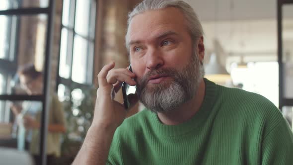 Middle Aged Businessman Talking on Phone and Drinking Coffee