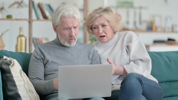 Happy Old Couple Talking on Video Chat on Laptop at Home