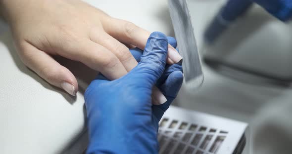 A Professional Manicurist Files a Client's Nails Closeup Hands