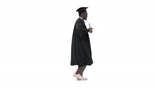 Excited African American Male Student in Graduation Robe Dancing with His Diploma While Walking on