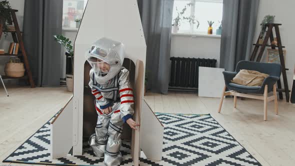 Cute Girl in Spacesuit Exiting Rocket Ship and Waving