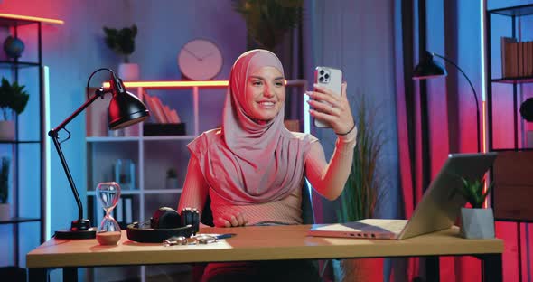 Woman in Hijab Enjoying Pleasant Video chat with Friend or Family on Beautifully Lighted room