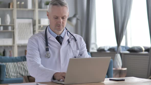 Senior Doctor Working On Laptop