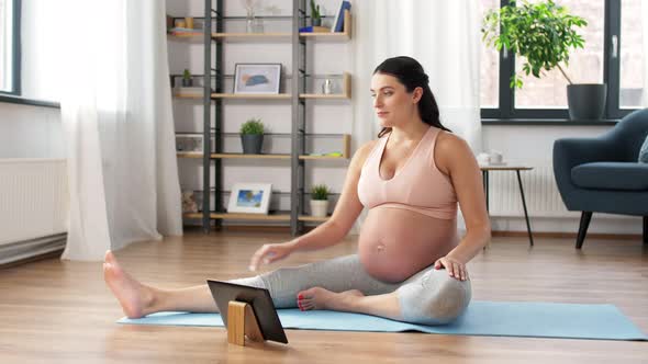 Pregnant Woman with Tablet Pc Doing Sports at Home