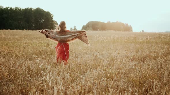 Young Farmer Girl Walking Through Wheat Field at Sunset. Modern Farming, Happy Youth and Profession