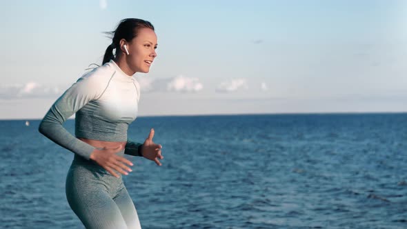 Athletic Woman Jogger Running on Sunset Beach Listening Music Enjoying Healthy Lifestyle Slowmo