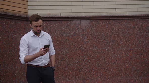 Businessman is Looking for Something on His Phone