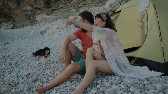 Lovely Couple looking at sea with Adorable dog breed king charles cavalier