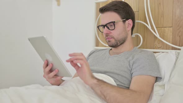 Ambitious Beard Young Man Using Tablet on Bed