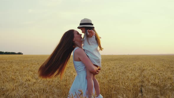 Slow Motion Mom with Daughter Spinning in Field