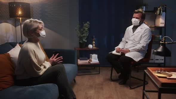 Psychologist Therapy Session Woman and Man Wearing Face Mask Sitting on the Sofa and Talking