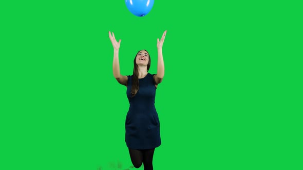 Girl playing with the balloon in front of a green screen