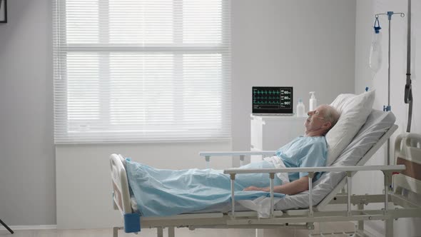 A Black Male Doctor in a Protective Mask Comes in and Talks to Patients with an Elderly White Man