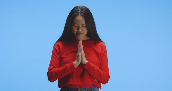 Young Woman Praying in Front of Camera