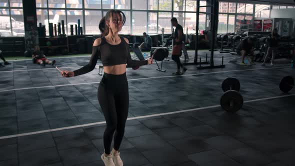 Young woman athlete trains cardio with jump rope, cardio and endurance training