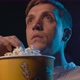 Man watching a horror movie at the cinema and eating popcorn - VideoHive Item for Sale