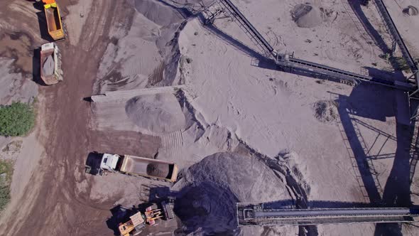 Excavators and Tractors Load Crushed Stone and Rock Into Dump Trucks