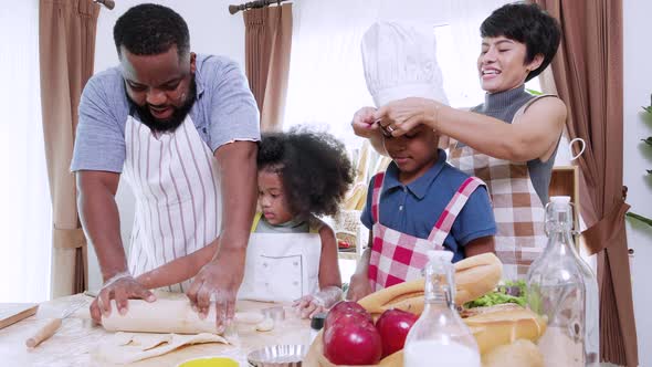 African American parents with girls enjoying cooking food. Family in kitchen